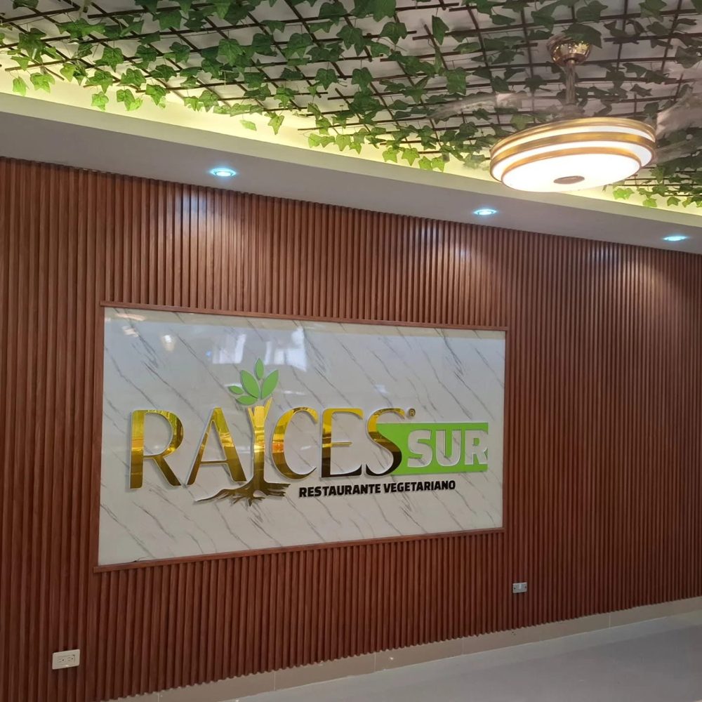 Interior del restaurante Raíces Sur con el rótulo dorado